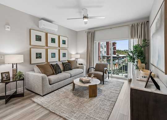 A living room with a grey couch, a coffee table, and a ceiling fan.
