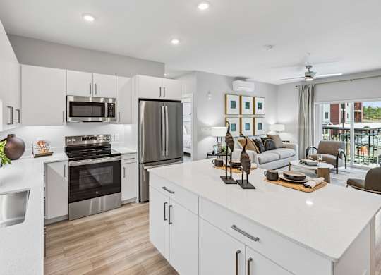 A modern kitchen with white cabinets and stainless steel appliances.