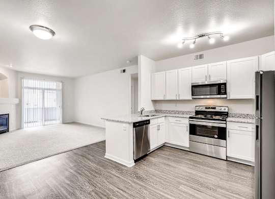 A spacious kitchen with white cabinets and stainless steel appliances.