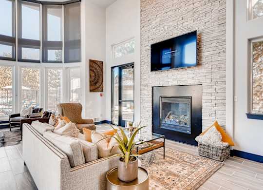 A living room with a fireplace and a flat screen TV mounted on the wall.