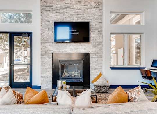 A living room with a fireplace and a flat screen TV mounted above it.