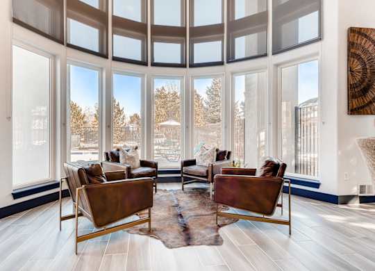 A living room with a large window and a view of trees.