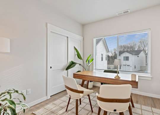 A dining room with a table and chairs.