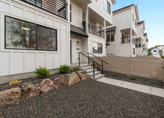 A white building with a gravel area in front.