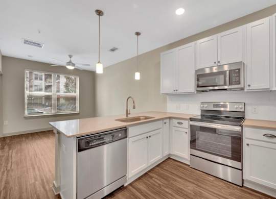 A kitchen with white cabinets and stainless steel appliances.
