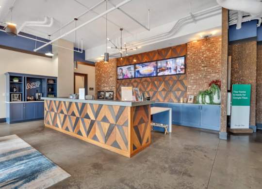 A reception area with a wooden counter and a TV mounted on the wall.