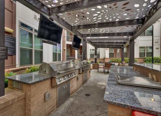 A patio with a grill and a flat screen TV.