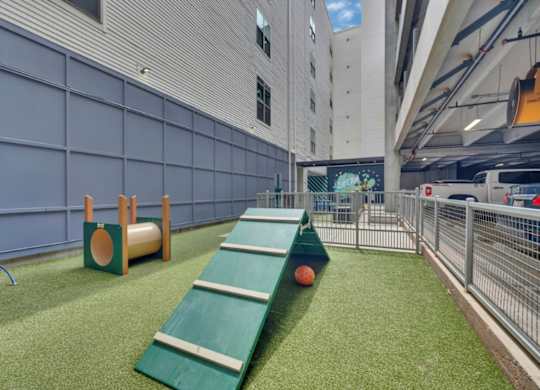 A playground area with a green slide and a basketball hoop.