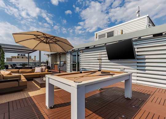A table and chairs are set up on a wooden deck.