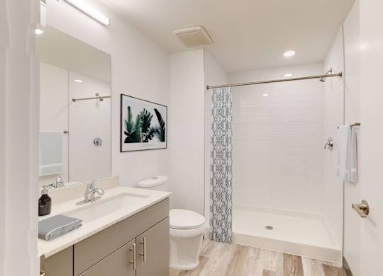 A white bathroom with a toilet, sink, and shower.