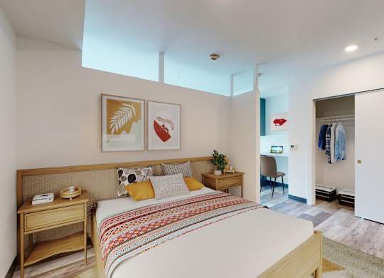 A bedroom with a bed, nightstand, and chair.