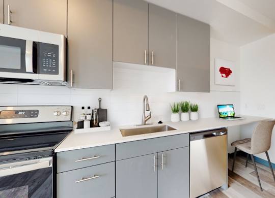 A modern kitchen with a microwave, oven, and a sink.