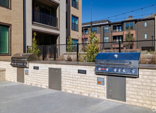 a brick wall with two grills in front of a building