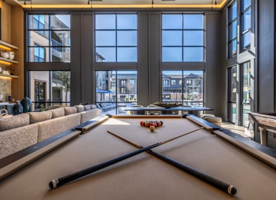 a game room with a pool table and a view of the city