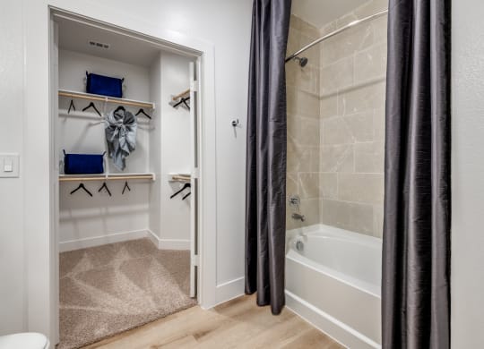 Aura 3Twenty Apartments bathroom with a shower and a tub and a closet