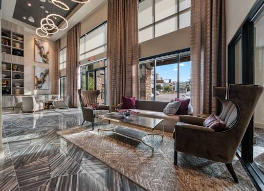 A living room with a brown sofa and a glass coffee table.
