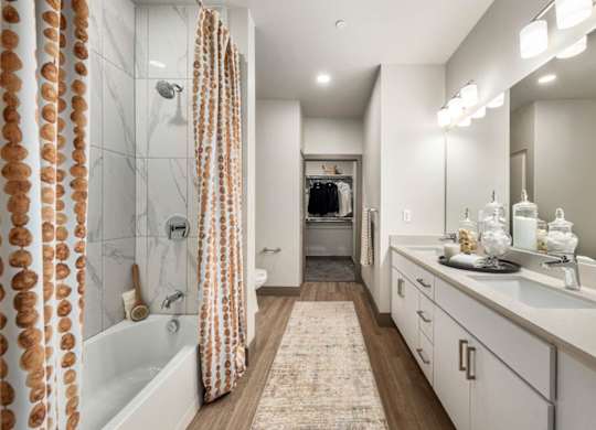 A bathroom with a white tub, sink, and shower curtain.
