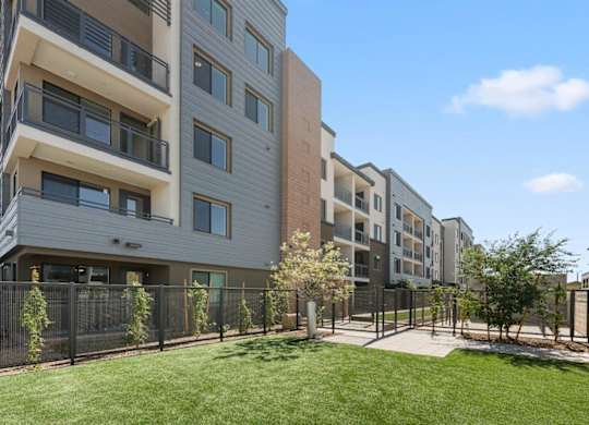 Apartment complex with a green lawn in front.
