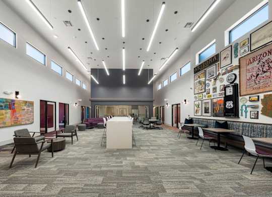 A modern office space with a long carpeted hallway and a variety of seating options.
