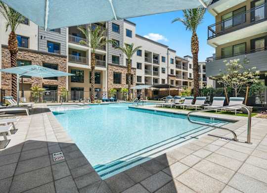A swimming pool surrounded by lounge chairs and umbrellas