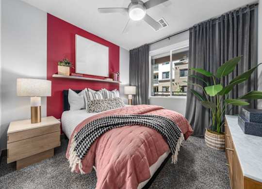 A bedroom with a bed, nightstand, and a ceiling fan.