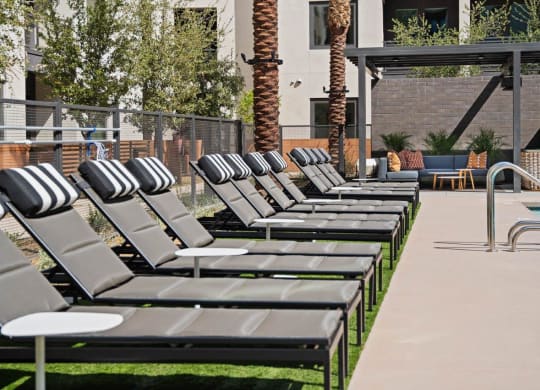 Aura Central Apartments Pool with Lounge Chairs