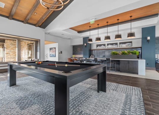 a pool table in a living room with a bar