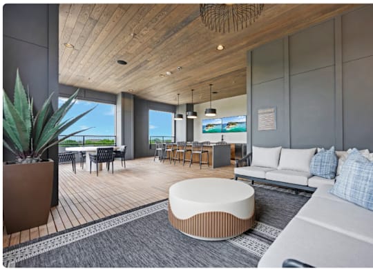A modern living room with a large window overlooking the ocean.