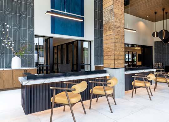 A modern kitchen with a long island and chairs.