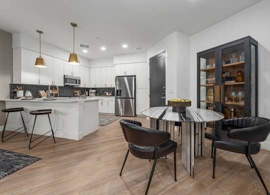 A modern kitchen with a dining table and chairs.