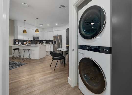 A modern laundry room with a washer and dryer built into the cabinetry.