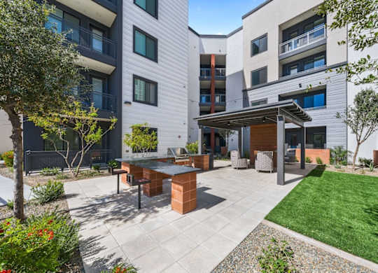 A modern outdoor patio area with a table and chairs.