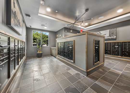 A room with a grey floor and black cabinets.