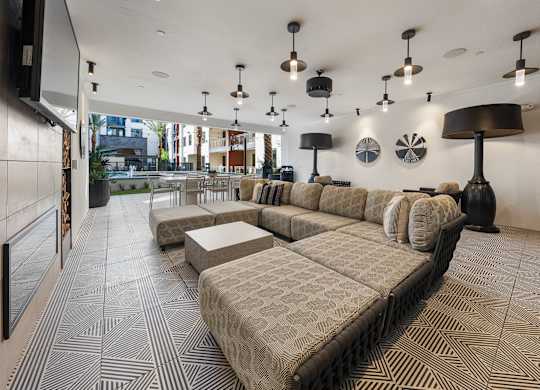 A large sectional sofa with a chaise lounge is in the middle of a room with a patterned floor.