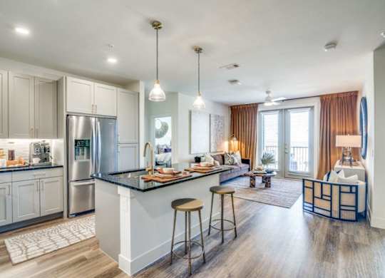 A modern kitchen with a bar and a living room area.