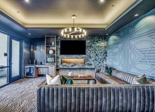 A modern living room with a grey sofa and a chandelier.