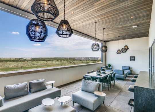 A modern outdoor living space with grey couches and tables.