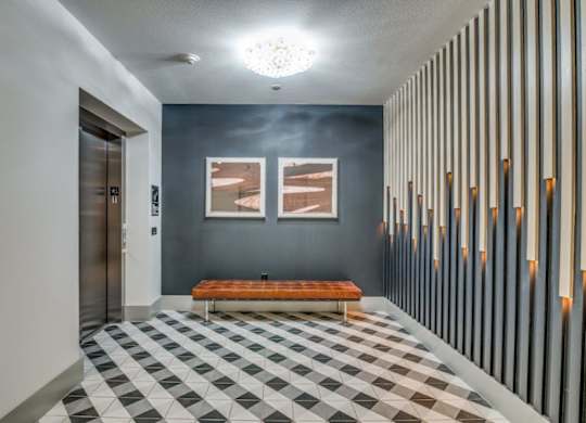 A hallway with a bench and a checkered floor.