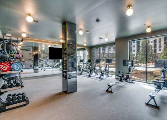 A gym with a variety of equipment including treadmills, weights, and exercise machines.