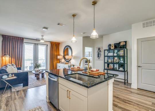 A modern kitchen with a black countertop and white cabinets.
