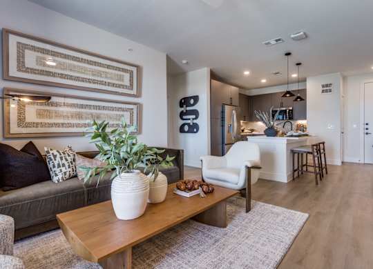A living room with a grey couch, a wooden coffee table, and a large framed artwork on the wall.