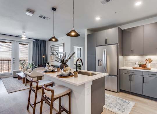 A modern kitchen with a dining area and a balcony.