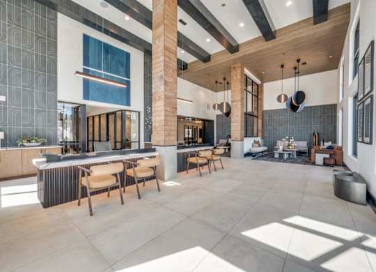 A modern kitchen with a large island and wooden chairs.