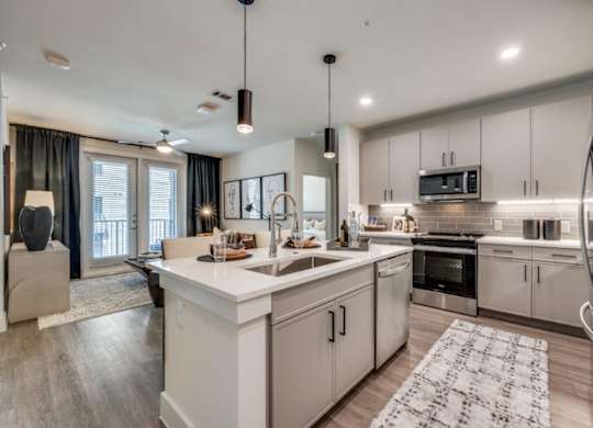A modern kitchen with white cabinets and stainless steel appliances.