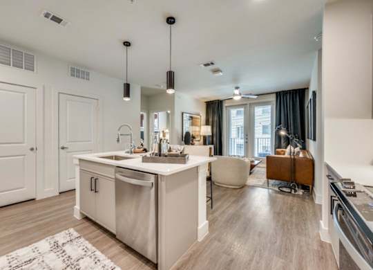 A modern kitchen with a large island and a dining area.