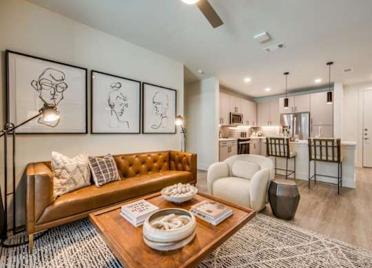 A living room with a brown leather couch and a coffee table with a bowl and a book on it.