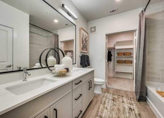 A bathroom with a sink, mirror, and a toilet.
