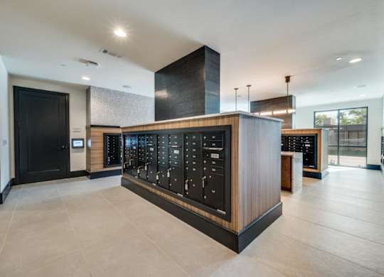 A modern lobby with a black and wood reception desk.