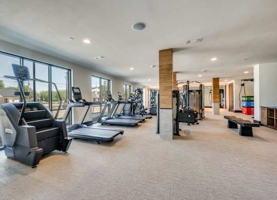 A spacious gym with treadmills, elliptical machines, and other exercise equipment.