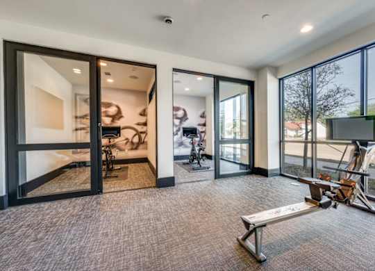 A room with a bench and a television with a view of the outdoors.